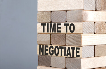 The text on the wooden blocks TIME TO NEGOTIATE