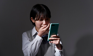 暗闇でスマホを見て驚く女子高生