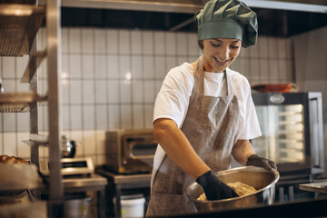 Female pastry baker at the kitchen making dough for croissants