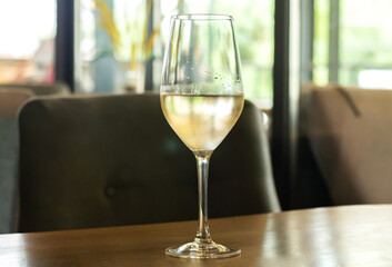 Glass of cold white wine on wooden table