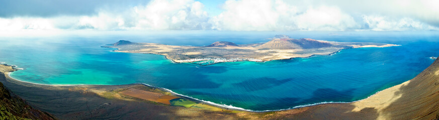 Panoramic view of La Graciosa island, the turquoise waters of el Rio and the Salinas del Rio on Lanzarote, Canary Islands, Spain.