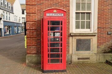 SIDMOUTH, DEVON, ENGLAND - APRIL 1ST 2021: A telephone box is situated by the side of the indoor market on Old Fore Street.