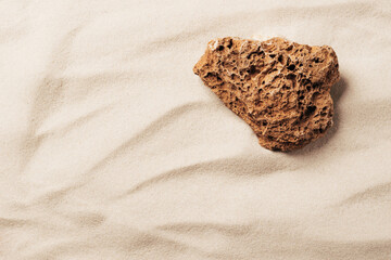 Creative summer podium made of stone on the background of sand, bright sunlight and shadows, mockup