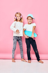 Fototapeta premium a boy in a cap and a girl skateboard headphones playing isolated background