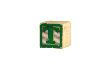 Distressed vintage green and white toy block, photographed against a white background. The letter T.