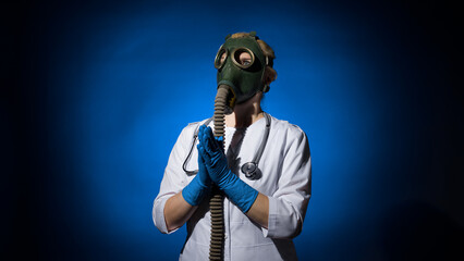 doctor woman in a gas mask and gloves prays on a blue background