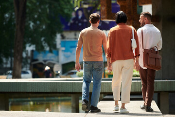 Obraz premium Group of friends walking around sunny city, view from back