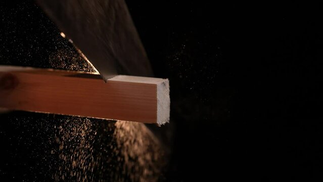 Man carpenter saws a wooden board with a hand saw. Isolated shon in 4k. Slow motion. Close up shot