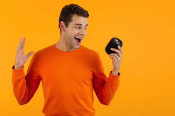 stylish young man holding wireless speaker
