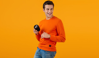 stylish young man holding wireless speaker - obrazy, fototapety, plakaty