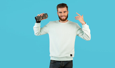 stylish young man holding wireless speaker