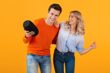 Obraz premium attractive stylish young couple holding wireless speaker