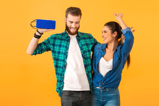 casual young couple holding wireless speaker
