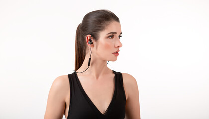 attractive woman in jogging black top listening to music on earphones