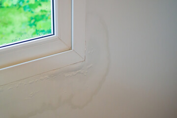 house wall near the window with some water stain show peeling paint