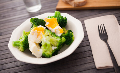 diet food. steamed broccoli with boiled egg on plate