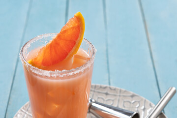 Classic paloma cocktail on blue wooden table. Copy space