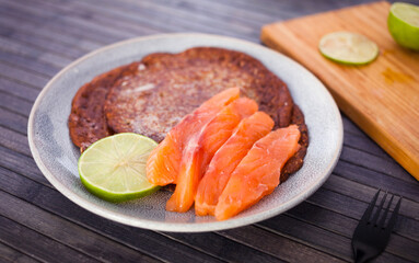 salted salmon fillet with buckwheat pancakes and lime