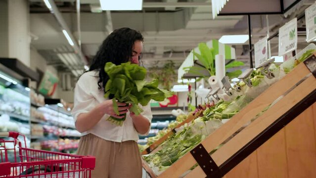 Attractive young woman a chooses cabbage salad, makes purchases in the supermarket, buys groceries healthy food, cabbage salad in the market, supermarket. Grocery shopping concept.