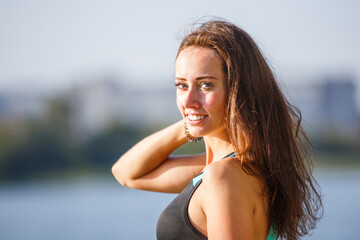 Naklejka premium Portrait of young smiling fitness girl in the morning. Beautiful fitness woman with white teeth