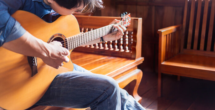 Asian Male Musician Hipster Playing Acoustic Guitar Or Practicing Guitar For Leisure Or Hobby Hobby Ideas For Relaxing Holiday At Home.