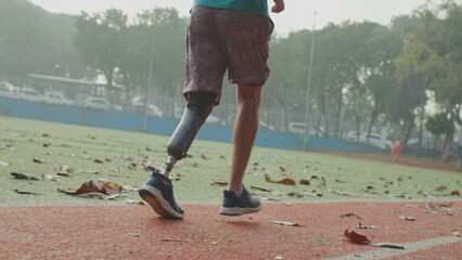 Disabled Athlete running with prosthetic leg at running track. Motivational amputee athlete runner