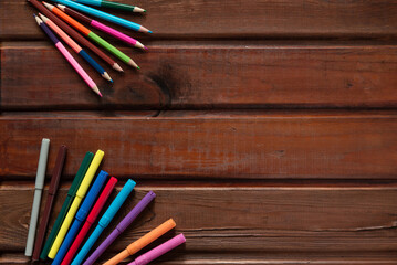 Obraz premium school stationery with markers and other supplies on brown wooden background. back to school concept