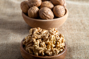 Peeled walnuts and whole walnuts on burlap sack