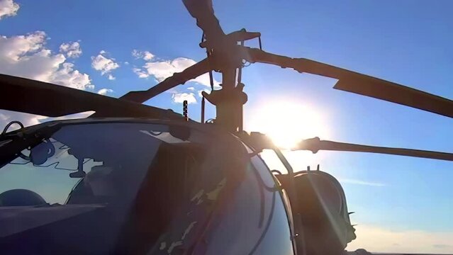 A close-up view of the coaxial rotors of a military helicopter as they spin before takeoff - seamless looping.