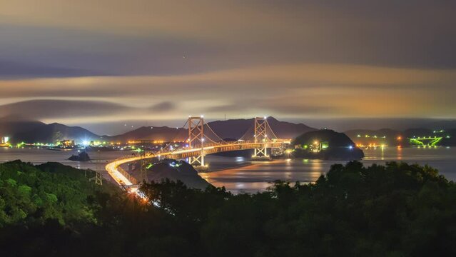 Night timelapse of traffic and fog moving over suspension bridge