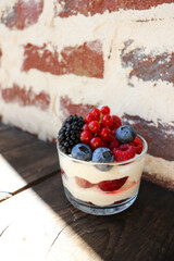 summer desserts with berries in a glass bowl and large glasses of homemade lemonade on a wooden  in a cafe