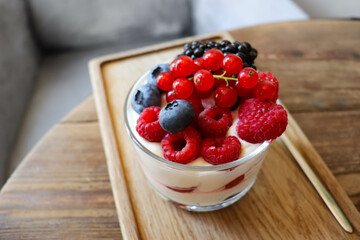 summer desserts with berries in a glass bowl and large glasses of homemade lemonade on a wooden  in a cafe