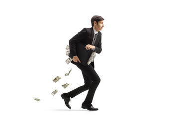 Full length profile shot of a businessman running and holding a briefcase full of money