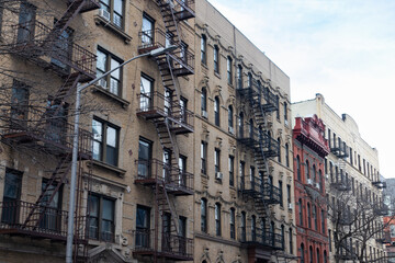 Fototapeta na wymiar Row of Old Brick Residential Buildings with Fire Escapes in Williamsburg Brooklyn of New York City