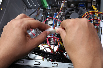 Technician's hands near top while making computer cable connections