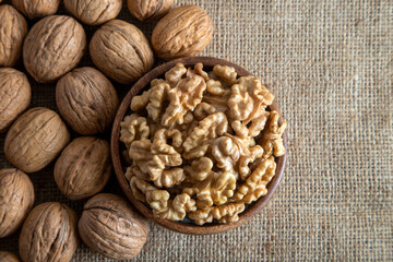 Peeled walnuts and whole walnuts on burlap sack
