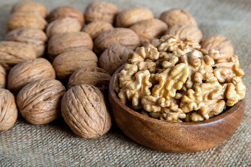 Peeled walnuts and whole walnuts on burlap sack