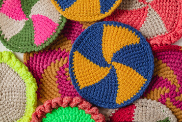 Blue yellow crochet cup coaster. Many round spiral coasters. Knited background.