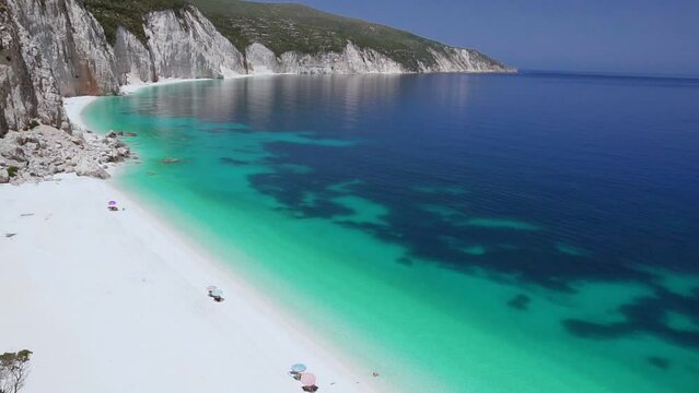 HD panning shot video of beautiful white beach with calm clear blue turquoise sea water. White paradise beach, summer feeling, vacation, travel in paradise. Amazing Ftery beach, kefalonia, Greece.