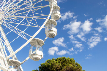 Ferris wheel in an amusement park in Italy. A giant wheel against the blue summer sky during the...