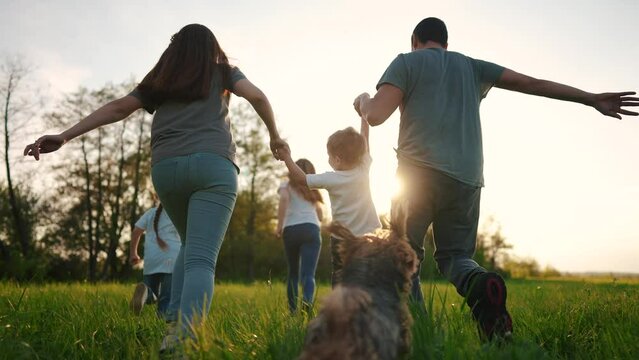 happy family running in the park in summer. mom and dad hold their son by the hands run throw up in the forest park on the grass in the summer lifestyle. happy family kid dream concept