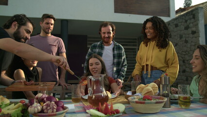 Barbecue Chef bringing food to friends united around table in backyard home