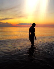Fototapeta na wymiar women on orange sunset at sea nature background 