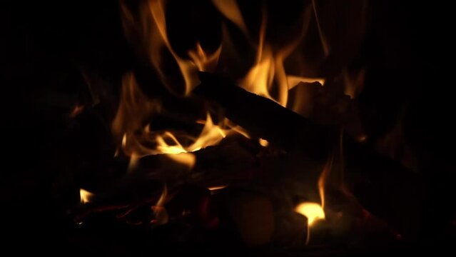 Glowing embers of bright red color, abstract background. Hot coals of a burning wood fire. Firewood is burning on the grill. Campfire embers fire texture. slow motion