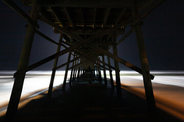 Long exposure underneath a boardwalk at night