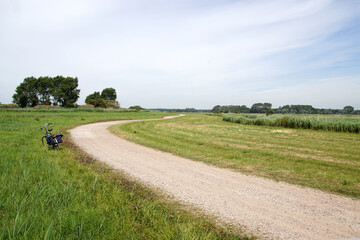Dutch dirt road through the meadows along the Ringvaart of the Bergermeer near the village of...