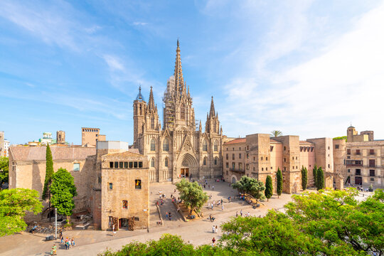 View of the Gothic Barcelona Cathedral of the Holy Cross and Saint Eulalia with surround buildings, plaza and the skyline of Barcelona in view.