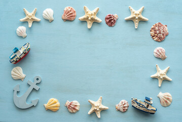 Starfishes and seashells laid out in the frame on blue wooden background.