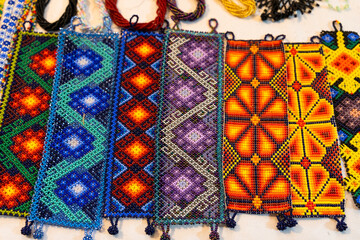 Handmade huichol bracelets with different colors and patterns at night market in Guadalajara, Mexico. Traditional Mexican handcraft souvenirs