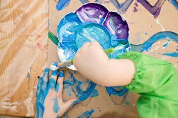 Zero waste. Corrugated cardboard cut and glued to make terrain. boy painting it to look like sea. DIY games at home. save the ocean concept.